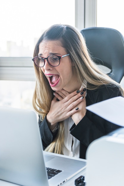 Zadziwiający młody bizneswoman patrzeje laptop