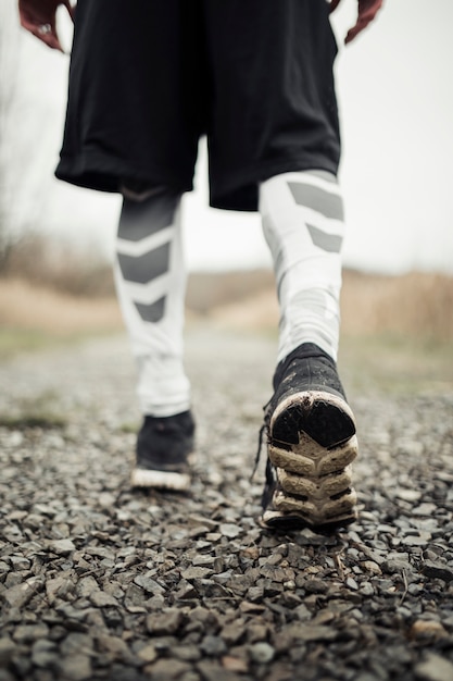 Bezpłatne zdjęcie zakończenie atleta męscy cieki w działających butach jogging na drodze