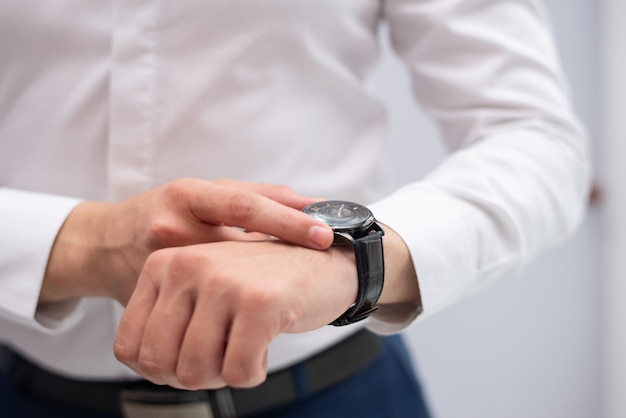 Zakończenie biznesmen patrzeje jego nowożytnego wristwatch