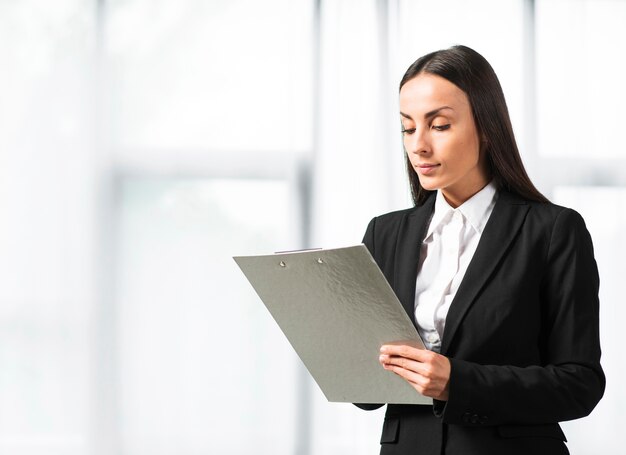 Zakończenie bizneswomanu writing na schowek pozyci blisko okno