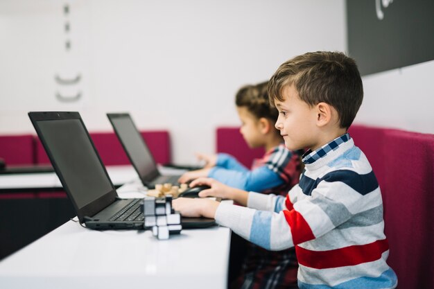 Zakończenie chłopiec używa laptop w sala lekcyjnej