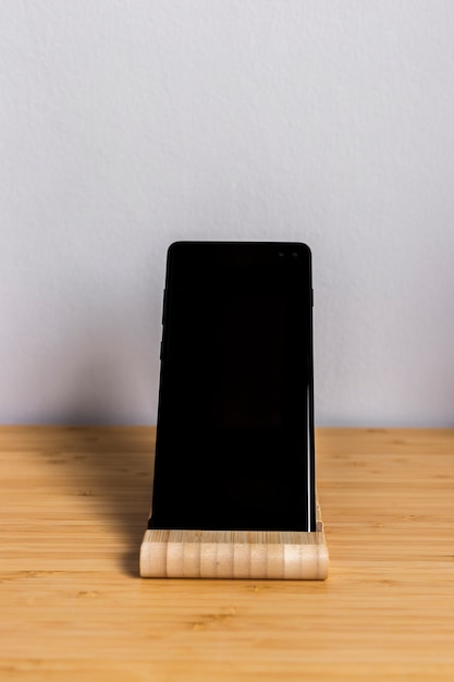 Bezpłatne zdjęcie zakończenie czarny smartphone na drewnianym biurku