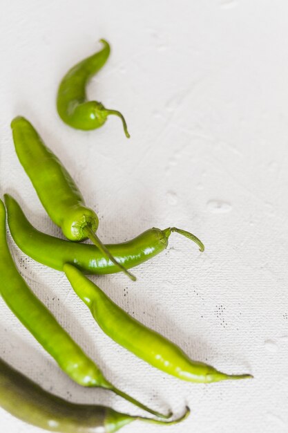 Zakończenie dojrzali zieleni chilies na białym tle