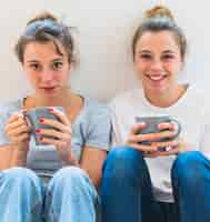 Bezpłatne zdjęcie zakończenie dwa siostrzanego mienia popielaty kawowy kubek