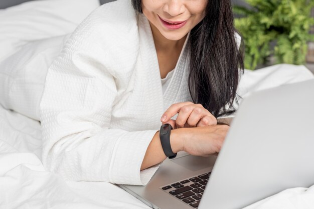 Zakończenie kobieta kłaść w łóżku z laptopem