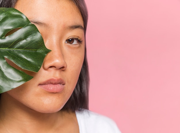 Zakończenie kobieta zakrywa jej oko z monstera liściem