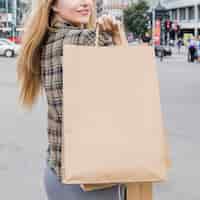 Bezpłatne zdjęcie zakończenie kobiety ręka z brown torba na zakupy