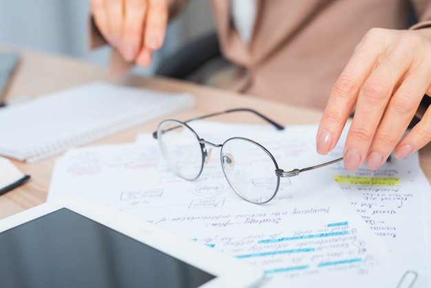 Zakończenie kobiety ręki mienia eyeglasses nad dokumentem