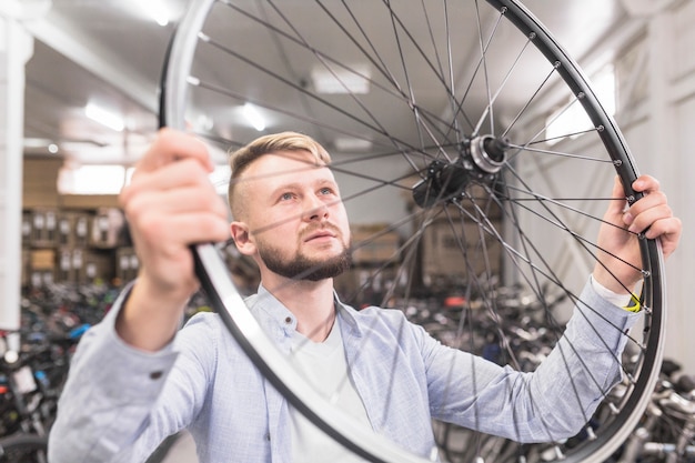 Zakończenie mężczyzna egzamininuje rowerowego obręcz w sklepie