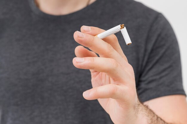 Zakończenie mężczyzna trzyma łamanego papieros w jego dwa palcu