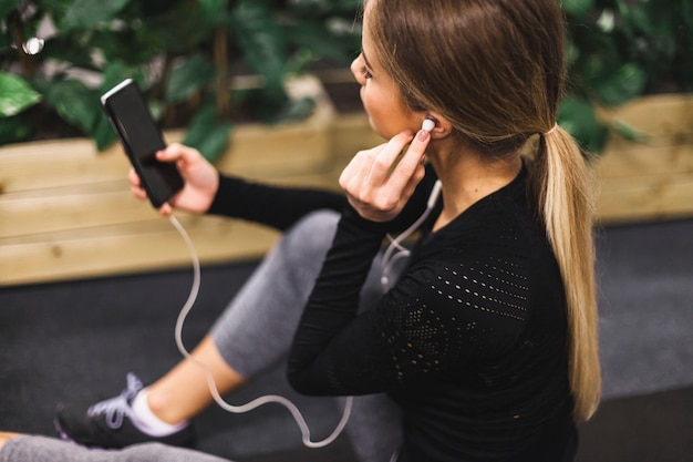 Bezpłatne zdjęcie zakończenie młoda kobieta słucha muzyka w gym