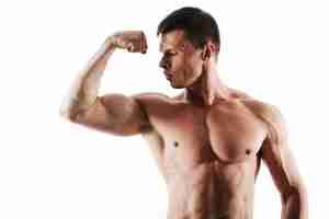 Bezpłatne zdjęcie zakończenie portret młody mięśniowy mężczyzna patrzeje jego triceps z krótkim ostrzyżeniem