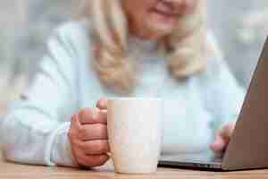 Bezpłatne zdjęcie zakończenie starsza kobieta używa laptop