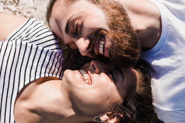 Zakończenie up pary lying on the beach na skałach przy morzem