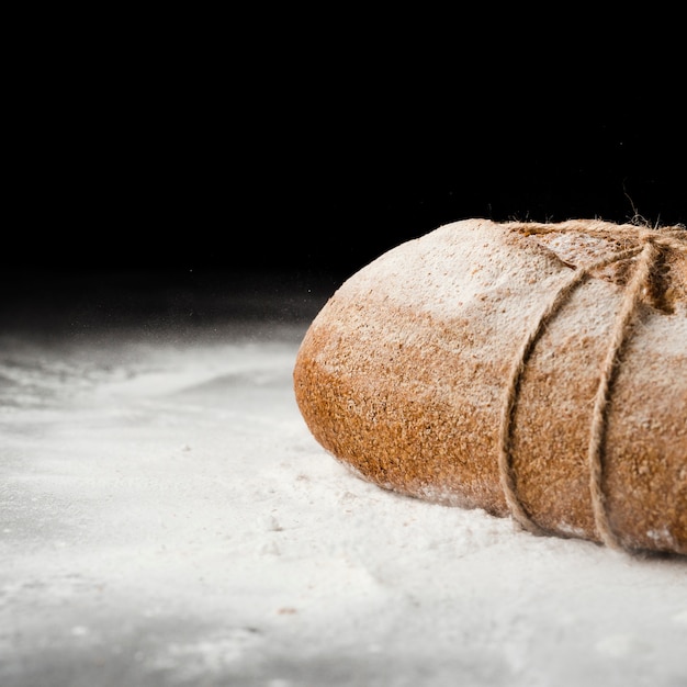 Bezpłatne zdjęcie zakończenie widok chleb i mąka na czarnym tle