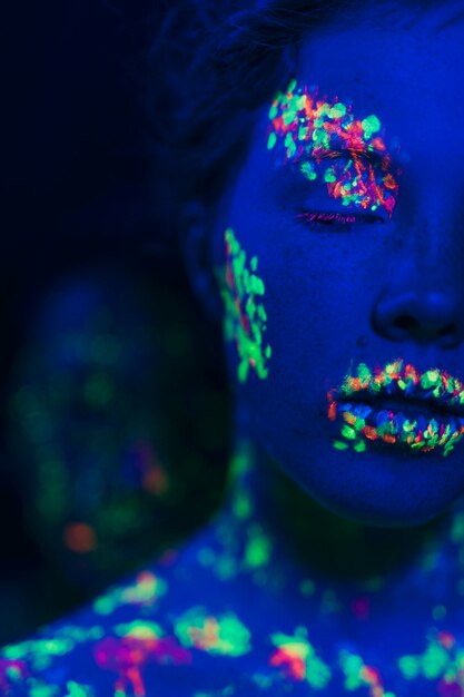 Zakończenie widok kobieta z fluorescencyjnym makijażem