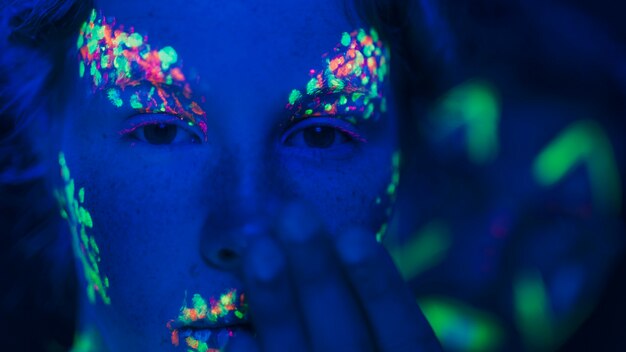 Zakończenie widok kobieta z kolorowym fluorescencyjnym makijażem