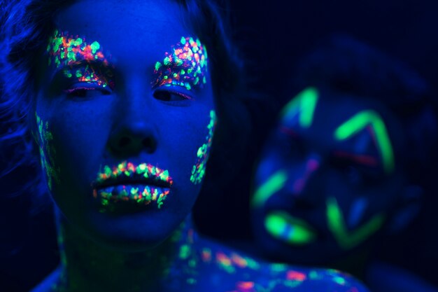 Zakończenie widok mężczyzna i kobieta z fluorescencyjnym makijażem
