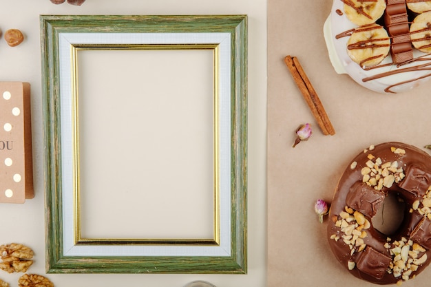 Bezpłatne zdjęcie zakończenie widok rama z ciastkami, cynamon i orzechy włoscy na bielu z kopii przestrzenią