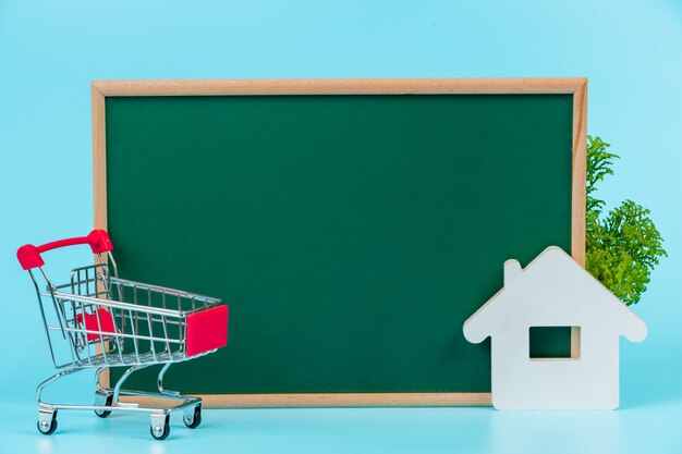 Zakupy online, podwójny wózek umieszczony na zielonej tablicy na niebiesko.