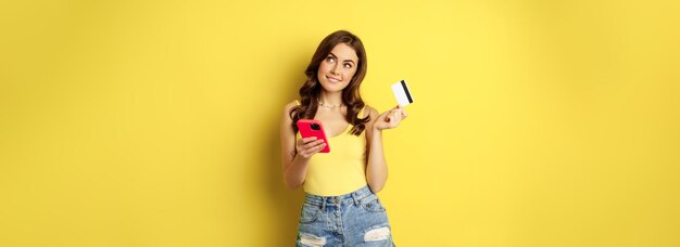 Zakupy Online Stylowa Brunetka Kobieta Trzyma Smartfon I Kartę Kredytową Płacąc W Aplikacji Za Pomocą Telefonu Komórkowego