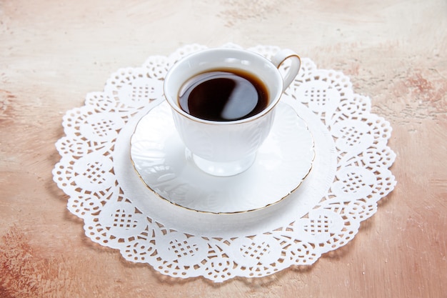 Zamknąć widok filiżanki czarnej herbaty na białej serwetce zdobione na kolorowe