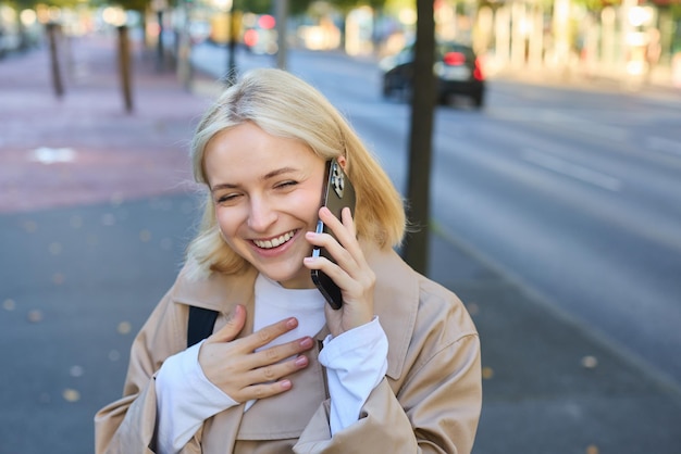 Bezpłatne zdjęcie zamknij portret nowoczesnej młodej kobiety śmiejącej się i uśmiechającej się idącej ulicą i odpowiedz