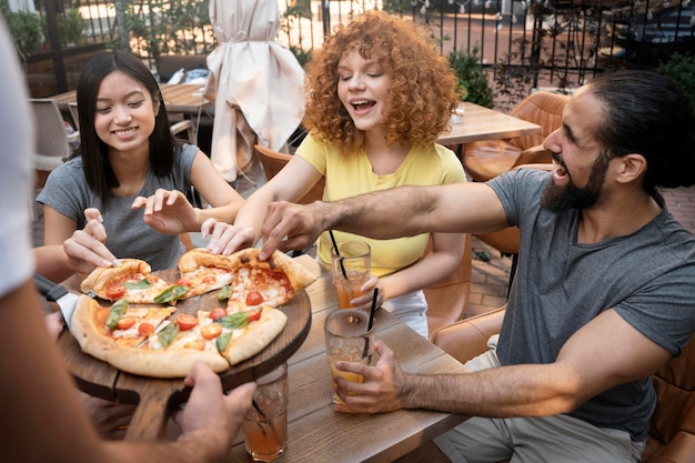 Bezpłatne zdjęcie zamknij przyjaciół ze smaczną pizzą?