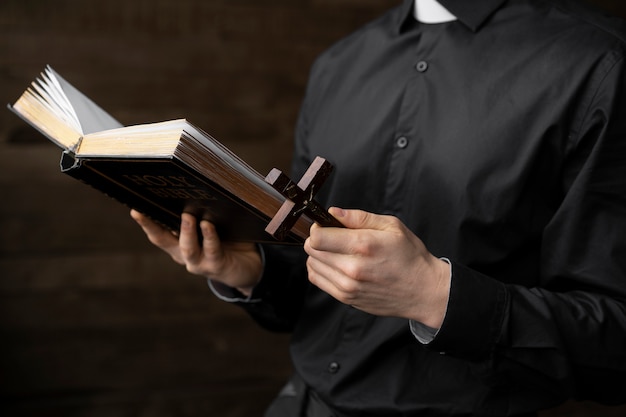 Zamknij się ksiądz trzymający krzyż i Biblię