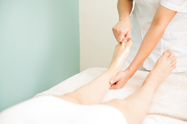 Zamknij się masażystka daje masaż stóp klientowi w spa. Dużo miejsca na kopie