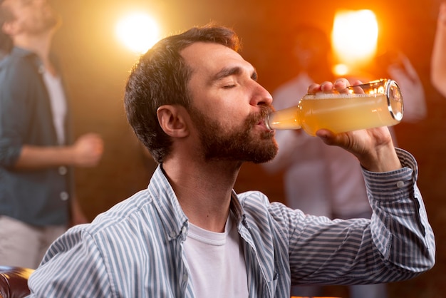 Bezpłatne zdjęcie zamknij się mężczyzna z drinkiem w klubie