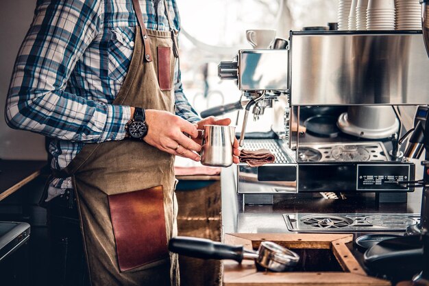 Zamknij się obraz człowieka przygotowującego cappuccino w ekspresie do kawy.