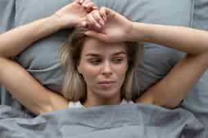 Bezpłatne zdjęcie zamknij się smutna kobieta w łóżku