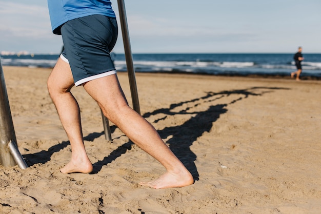 Zamknij się widok człowieka rozciągania na plaży