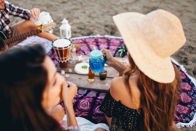 Bezpłatne zdjęcie zamknij się widok przyjaciół siedzących na plaży