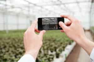 Bezpłatne zdjęcie zamyka up mężczyzna robi fotografii greenery