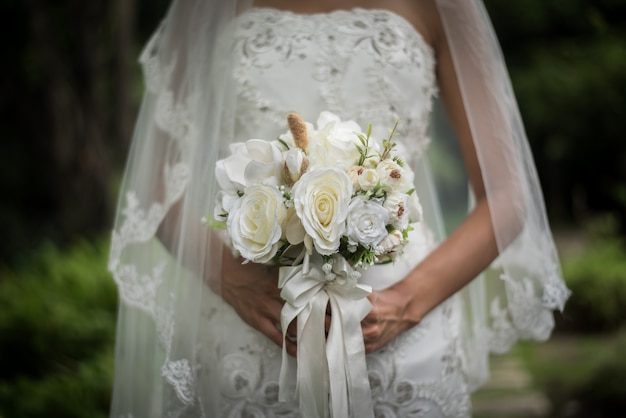 Zamyka up panna młoda z ślubnym bridal kwiatem w rękach.