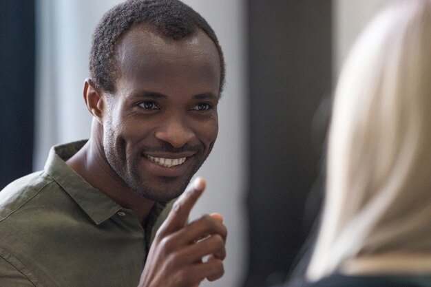 Zamyka up uśmiechnięty młody afrykański mężczyzna wskazuje palec