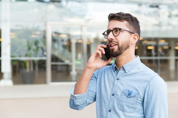 Zamyślony facet w okularach mówi na telefon