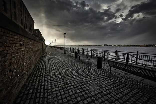 Zapierający dech w piersiach strzał z chodnika w pobliżu morza w Liverpoolu w pochmurny dzień