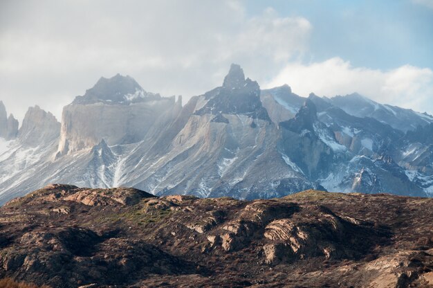 Zapierający dech w piersiach widok na zaśnieżone góry pod zachmurzonym niebem w Patagonii w Chile