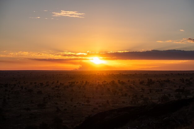 Zapierający dech w piersiach zmierzch w kolorowym niebie nad pustynią w Tsavo zachodzie, Kenja, Kilimanjaro