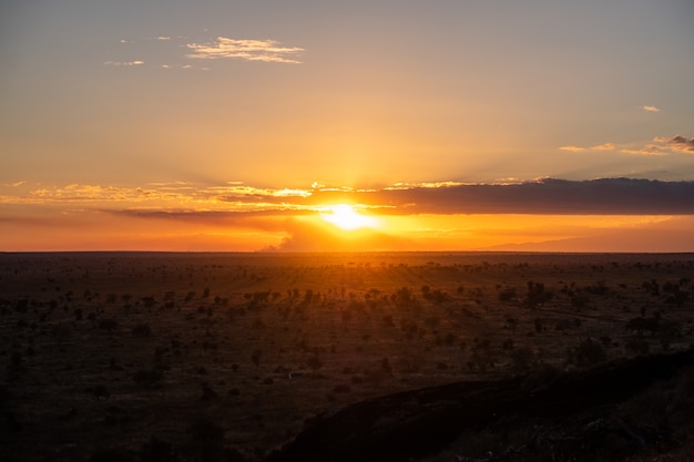 Zapierający dech w piersiach zmierzch w kolorowym niebie nad pustynią w Tsavo zachodzie, Kenja, Kilimanjaro