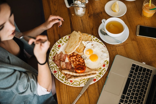 Bezpłatne zdjęcie zasięrzutny widok kobieta ma zdrowego śniadanie w caf���