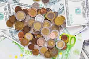 Bezpłatne zdjęcie zasięrzutny widok kruszcowe monety nad rozprzestrzenionymi euro banknotami