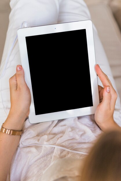 Zasięrzutny widok trzyma cyfrową pastylkę z pustym ekranem kobieta