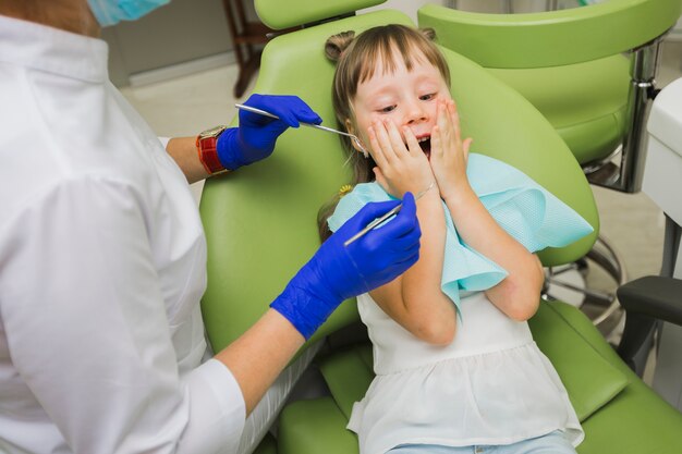 Zaskoczony dziewczyna u dentysty