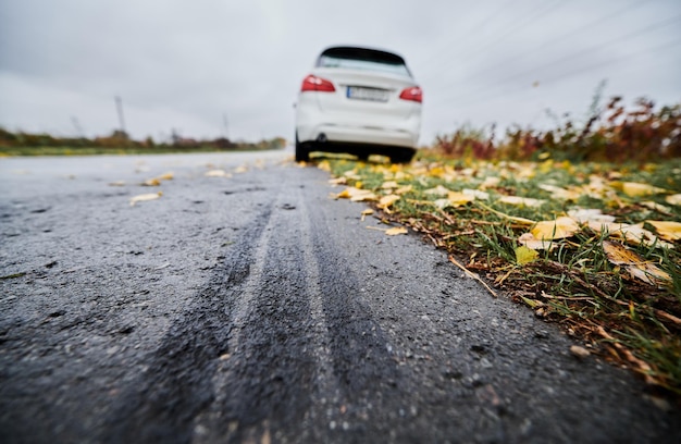 Bezpłatne zdjęcie zatrzymany biały samochód z przebitą oponą na poboczu drogi