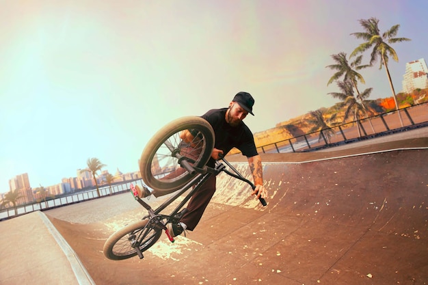 Zawodnik BMX wykonuje triki w skateparku o zachodzie słońca