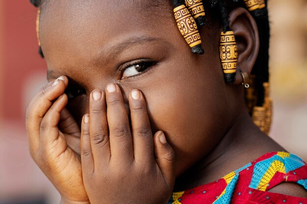 Zbliżenie afrykańskiej dziewczyny zakrywającej twarz